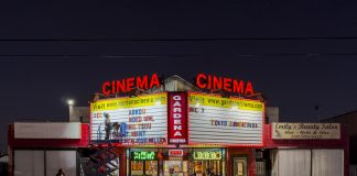 Judy Kim replacing marquee letters at Gardena Cinema entrance at night