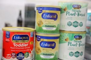 Measuring scoop inside a container of powdered baby formula, focusing on infant nutrition and safety.