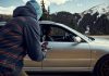 Korean Senior Parking Lot Robbery Alarms LA Community a man in a hoodie is looking out the window of a car