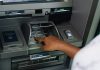 Bank of America Settles 7-Eleven ATM Fee Lawsuit a person using an atm machine to pay money