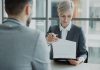 California Capping Law Could Cost Attorneys Their Licenses Woman in suit shows document to man